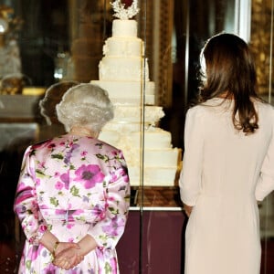 Kate Middleton devant la réplique de son gâteau de mariage avec la reine Elizabeth II, le 22 juin 2011 au palais de Buckingham.