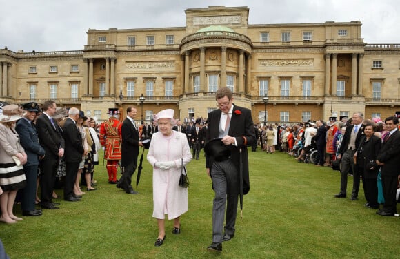 La reine Elizabeth II et le comte William Peel, Lord Chamberlain, dans les jardins de Buckingham en mai 2013.