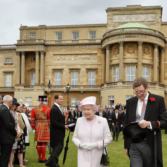 La reine Elizabeth II et le comte William Peel, Lord Chamberlain, dans les jardins de Buckingham en mai 2013.