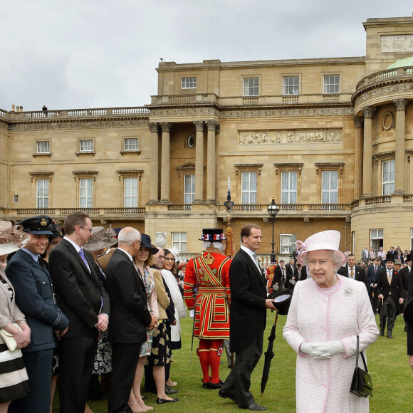 La reine Elizabeth II et le comte William Peel, Lord Chamberlain, dans les jardins de Buckingham en mai 2013.