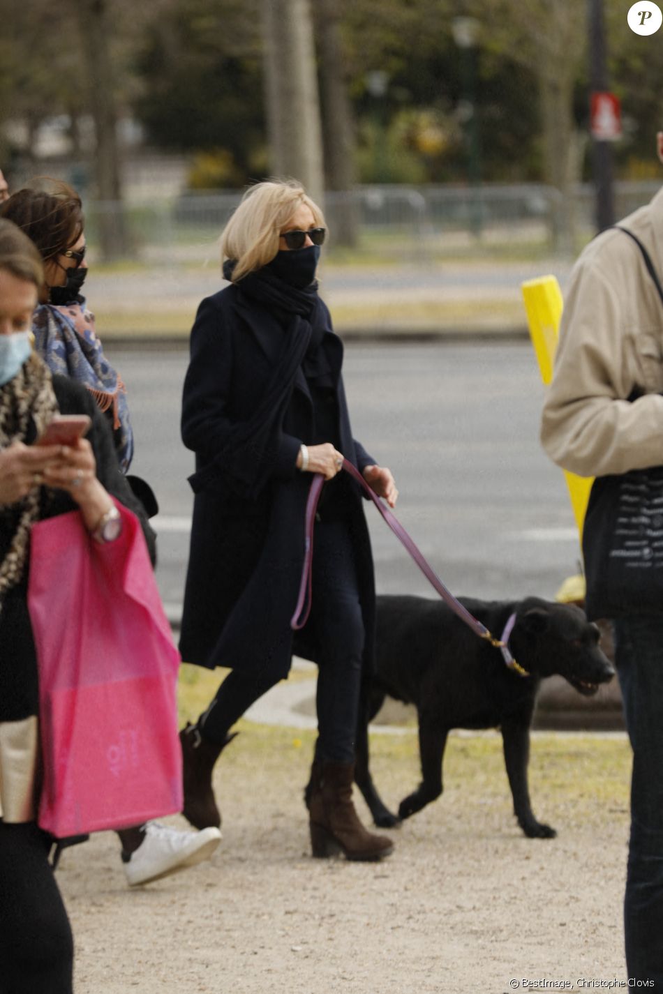 Semi-exclusif - La première Dame Brigitte Macron balade son chien, Némo, et Fabienne Moszer (directrice des relations Extérieures chez Accor Arena) sur l'avenue des Champs-Élysées, à Paris, France, le 26 mars 2021. La première Dame s'est rendue à l'exposition des 20 statues du "Chat" de Philippe Geluck. © Christophe Clovis/Bestimage