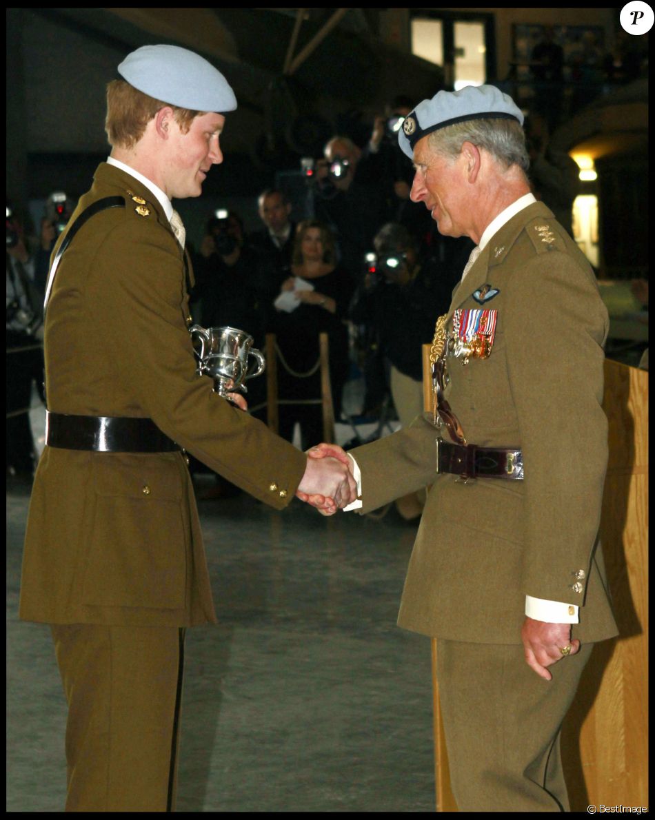 Le prince Harry reçoit une poignée de main de son père à l'occasion de la fin de sa formation de pilote d'hélicoptère militaire.