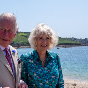 Le prince Charles et Camilla Parker Bowles, la duchesse de Cornouailles se promènent le long de la plage à St Mary's lors de leur visite aux îles Scilly, le 20 juillet 2021.
