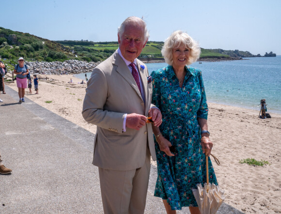 Le prince Charles et Camilla Parker Bowles, la duchesse de Cornouailles se promènent le long de la plage à St Mary's lors de leur visite aux îles Scilly, le 20 juillet 2021.