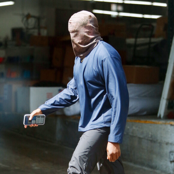 Exclusif - Kanye West se protège de la canicule en portant une cagoule sur la tête dans la rue à Los Angeles le 15 juin 2021.