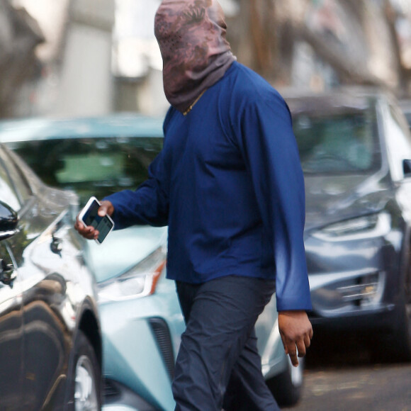 Exclusif - Kanye West se protège de la canicule en portant une cagoule sur la tête dans la rue à Los Angeles le 15 juin 2021.