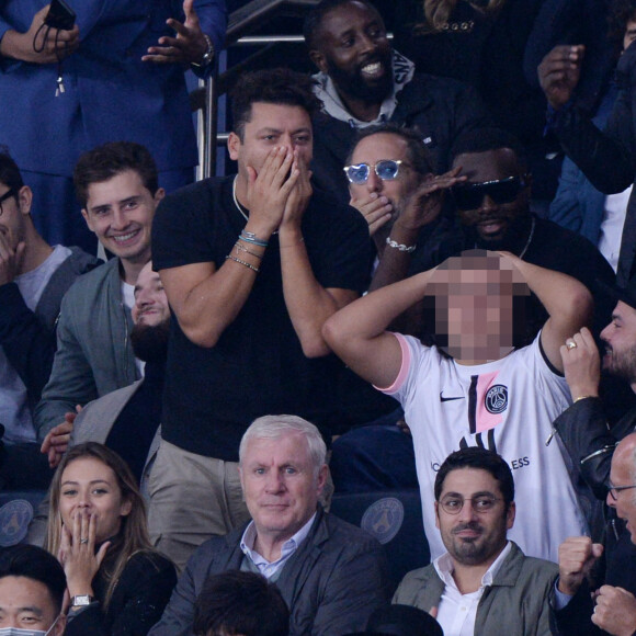 Ladj Ly, Kev Adams, Gims, Gad Elmaleh et son fils Noë assistent au match de football opposant le PSG à l'Olympique Lyonnais au Parc des Princes. Paris, le 19 septembre 2021.