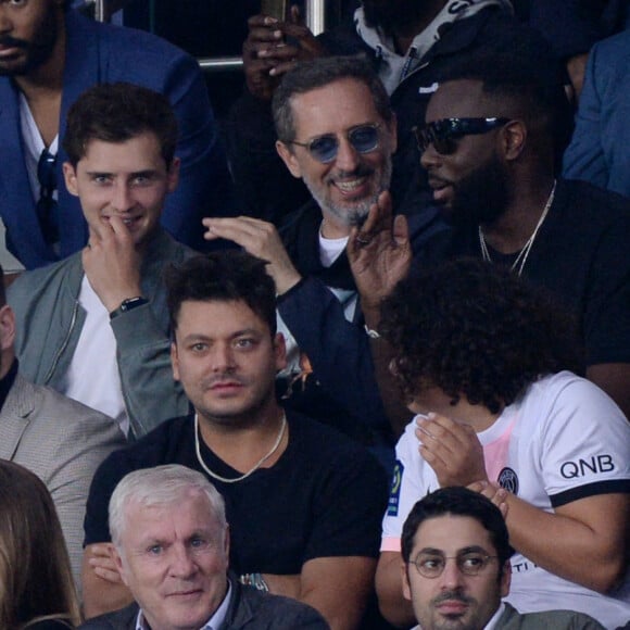 Ladj Ly, Kev Adams, Gims, Gad Elmaleh et son fils Noë assistent au match de football opposant le PSG à l'Olympique Lyonnais au Parc des Princes.