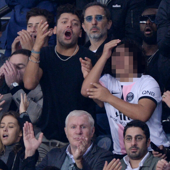 Kev Adams, Gims, Gad Elmaleh et son fils Noë assistent au match de football opposant le PSG à l'Olympique Lyonnais au Parc des Princes. Paris, le 19 septembre 2021.