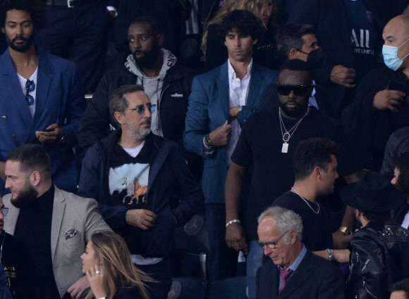 Ladj Ly, Gad Elmaleh et Gims assistent au match de football opposant le PSG à l'Olympique Lyonnais au Parc des Princes. Paris, le 19 septembre 2021.