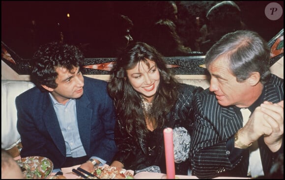 Archives - Michel Boujenah, Jean-Paul Belmondo et sa compagne Carlos Sotto Mayor fêtent la sortie de l'album de Carlos Sotto Mayor lors d'une soirée à Paris. 1985.