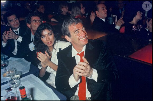 Archives - Bernard Tapie, Darry Cowl, Jean-Paul Belmondo et sa compagne Carlos Sotto Mayor lors d'une soirée à L'Alcazar à Paris. 1985.