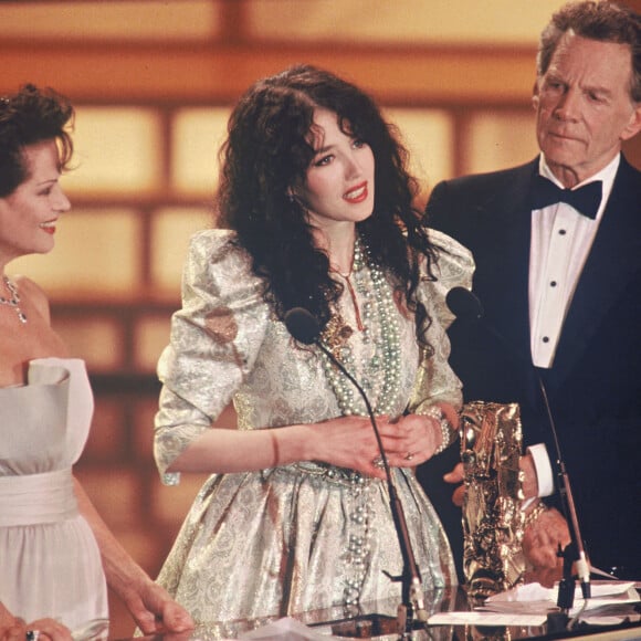 Isabelle Adjani reçoit le César de la meilleure actrice pour le film "Camille Claudel" en 1989, en présence de Claudia Cardinale et Jean-Pierre Aumont.