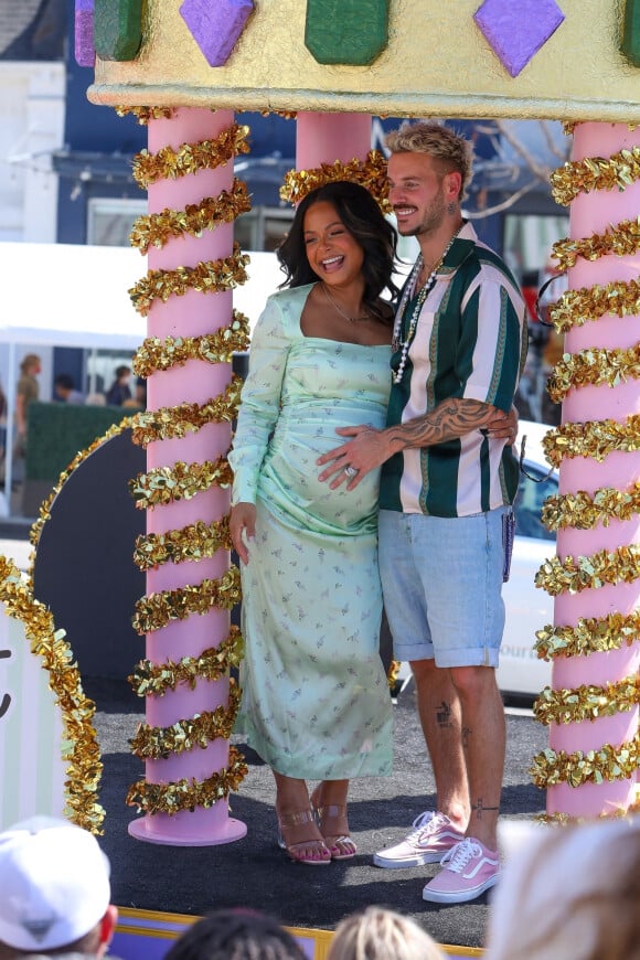 Christina Milian, enceinte de son troisième enfant, et son compagnon M Pokora (Matt) font la promotion de la marque "Beignet Box" de Christina sur un char lors d'une parade à Los Angeles le 10 avril 2021.