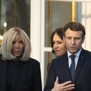 Le président de la République française, Emmanuel Macron et sa femme la Première Dame, Brigitte Macron posent pour une photo de groupe avec les premières lauréates de l'Initiative Marianne pour les défenseurs des droits de l'homme à la suite d'une cérémonie de remise de prix dans le cadre de la journée internationale de la femme, au palais de l'Elysée à Paris, France, le 8 mars 2022.