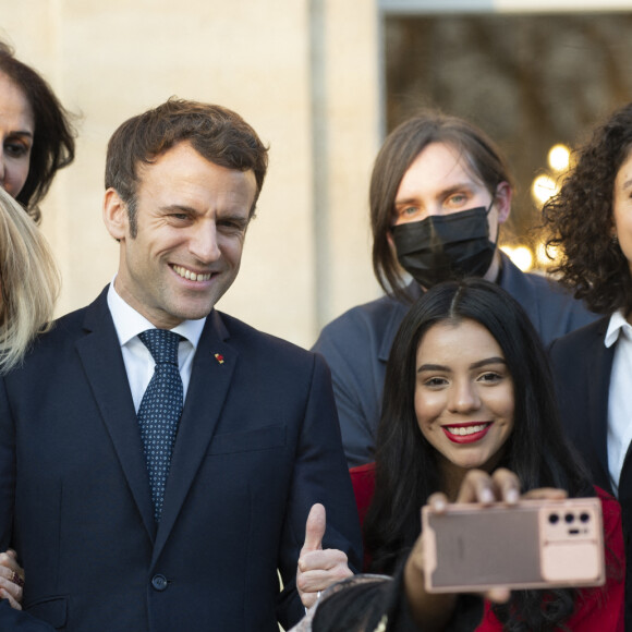 Le président de la République française, Emmanuel Macron et sa femme la Première Dame, Brigitte Macron posent pour une photo de groupe avec les premières lauréates de l'Initiative Marianne pour les défenseurs des droits de l'homme à la suite d'une cérémonie de remise de prix dans le cadre de la journée internationale de la femme, au palais de l'Elysée à Paris, France, le 8 mars 2022.