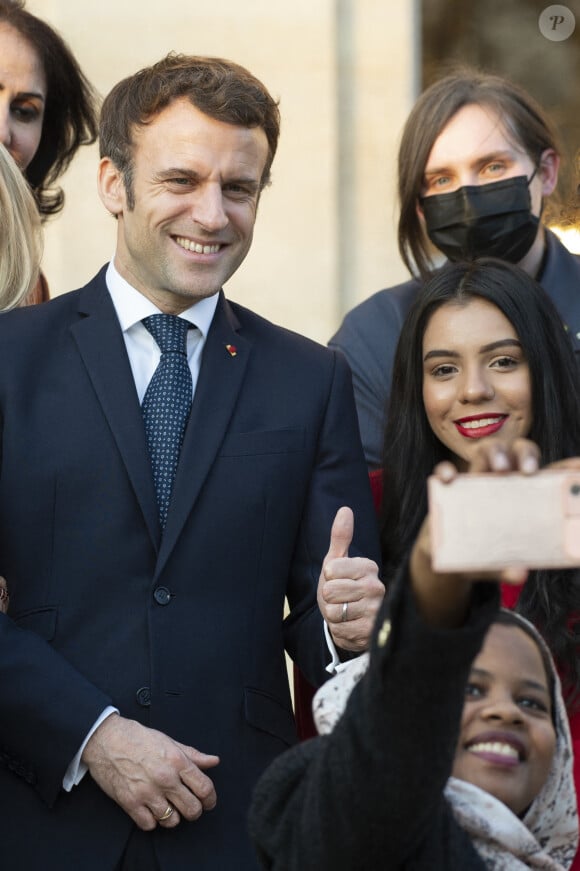 Le président de la République française, Emmanuel Macron et sa femme la Première Dame, Brigitte Macron posent pour une photo de groupe avec les premières lauréates de l'Initiative Marianne pour les défenseurs des droits de l'homme à la suite d'une cérémonie de remise de prix dans le cadre de la journée internationale de la femme, au palais de l'Elysée à Paris, France, le 8 mars 2022.