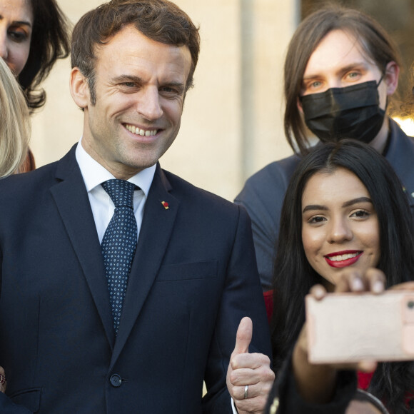 Le président de la République française, Emmanuel Macron et sa femme la Première Dame, Brigitte Macron posent pour une photo de groupe avec les premières lauréates de l'Initiative Marianne pour les défenseurs des droits de l'homme à la suite d'une cérémonie de remise de prix dans le cadre de la journée internationale de la femme, au palais de l'Elysée à Paris, France, le 8 mars 2022.