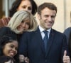 Le président de la République française, Emmanuel Macron et sa femme la Première Dame, Brigitte Macron, très complices, posent pour une photo de groupe avec les premières lauréates de l'Initiative Marianne pour les défenseurs des droits de l'homme à la suite d'une cérémonie de remise de prix dans le cadre de la journée internationale de la femme, au palais de l'Elysée à Paris