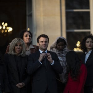 Le président de la République française, Emmanuel Macron et sa femme la Première Dame, Brigitte Macron posent pour une photo de groupe avec les premières lauréates de l'Initiative Marianne pour les défenseurs des droits de l'homme à la suite d'une cérémonie de remise de prix dans le cadre de la journée internationale de la femme, au palais de l'Elysée à Paris, France, le 8 mars 2022.