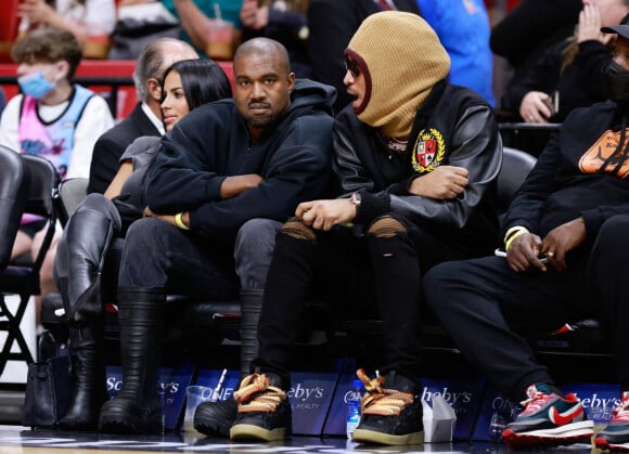 Kanye West, sa compagne Chaney Jones et le rappeur Future assistent au match de NBA opposant les Miami Heat aux Minnesota Timberwolves, à la FTX Arena. Miami, le 13 mars 2022.