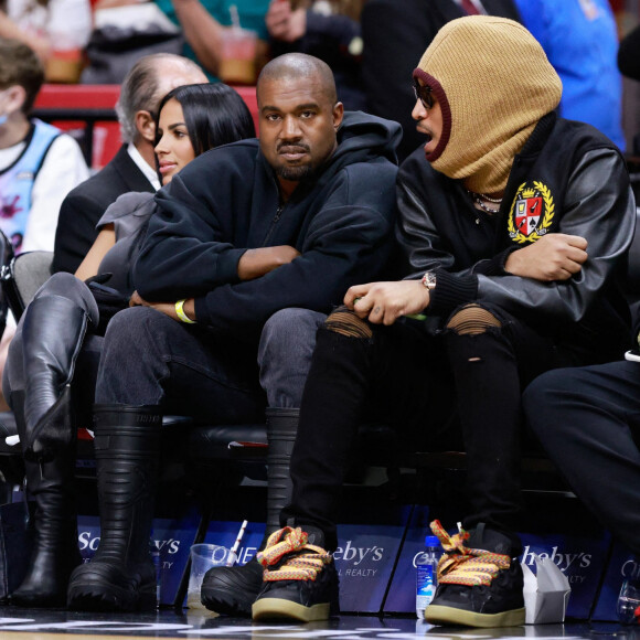 Kanye West, sa compagne Chaney Jones et le rappeur Future assistent au match de NBA opposant les Miami Heat aux Minnesota Timberwolves, à la FTX Arena. Miami, le 13 mars 2022.