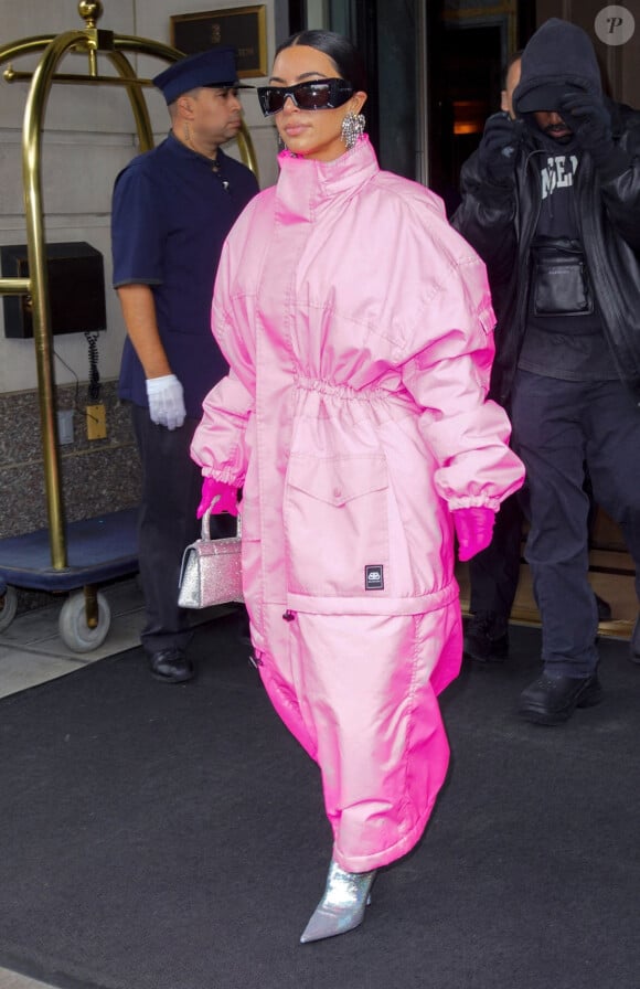 Kim Kardashian (emmitouflée dans un long manteau rose) sort de l'hôtel Ritz Carlton pour se rendre dans les studios de l'émission "Saturday Night Live" (SNL) à New York, le 9 octobre 2021. 