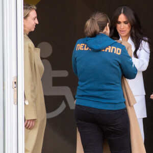 Meghan Markle prête son manteau à une athlète pour couvrir son bébé lors de la réception organisée par la ville de La Haye et le ministère néerlandais de la Défense, au Nations Home, la veille de l'ouverture des Invictus Games 2020 à Zuiderpark, La Haye, le 15 avril 2022. 