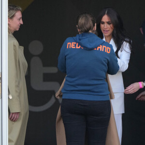 Meghan Markle prête son manteau à une athlète pour couvrir son bébé lors de la réception organisée par la ville de La Haye et le ministère néerlandais de la Défense, au Nations Home, la veille de l'ouverture des Invictus Games 2020 à Zuiderpark, La Haye, le 15 avril 2022. 