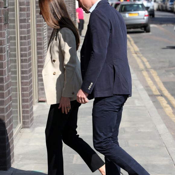 Le prince William, duc de Cambridge, et Catherine (Kate) Middleton, duchesse de Cambridge, visitent le comité d'urgence de Londres, à la rencontre de bénévoles de retour de leur mission humanitaire en Ukraine, le 21 avril 2022. En guise de soutien, le couple princier porte un badge aux couleurs du drapeau ukrainien. 