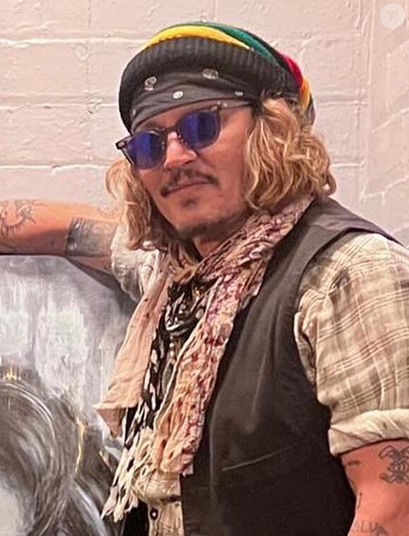 L'artiste Scott Greenwood présente son oeuvre à Johnny Depp à l'o2 apollo de Manchester, Royaume Uni, le 4 juin 2022. Johnny Depp a signé des autographe de copies pour toute la famille de l'artiste. 