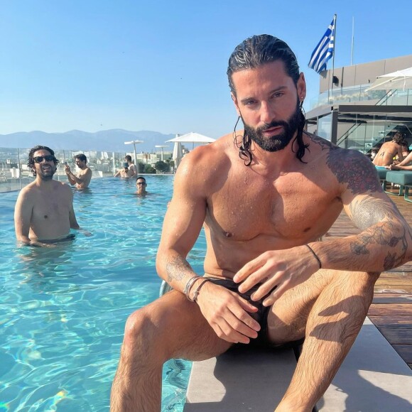 Hugo Manos pose sur Instagram (avec Max Boublil en fond) - La bande des Grosses Têtes en voyage à Athènes à l'invitation de Laurent Ruquier. Juin 2022.