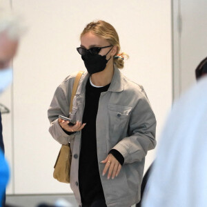 Exclusif - Lily-Rose Depp, escortée par un garde du corps, arrive à l'aéroport de Los Angeles, après avoir fêté son 23 ème anniversaire. Dans le même temps, son père J.Depp attend le verdict dans son procès en diffamation contre son ex-femme, A.Heard. Le 31 mai 2022. 