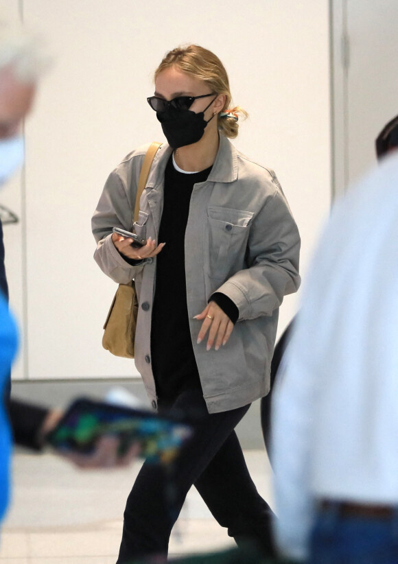 Exclusif - Lily-Rose Depp, escortée par un garde du corps, arrive à l'aéroport de Los Angeles, après avoir fêté son 23 ème anniversaire. Dans le même temps, son père J.Depp attend le verdict dans son procès en diffamation contre son ex-femme, A.Heard. Le 31 mai 2022. 