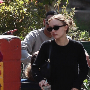 Exclusif - Lily Rose Depp fait une pause cigarette avec une amie après le brunch à Los Angeles, le 27 février 2022. 