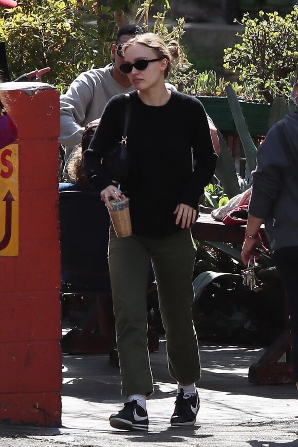 Exclusif - Lily Rose Depp fait une pause cigarette avec une amie après le brunch à Los Angeles, le 27 février 2022. 