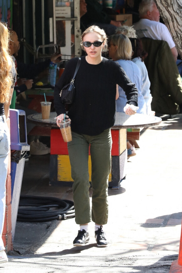 Exclusif - Lily-Rose Depp prend un verre avec une amie en terrasse d'un café à West Hollywood le 27 février 2022. 