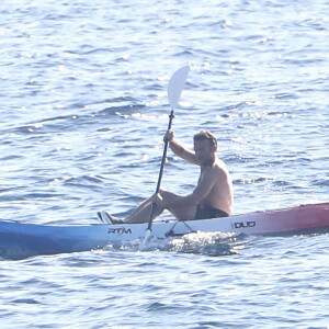 Exclusif - Le président Emmanuel Macron fait du canoë-kayak lors de ses vacances au Fort de Brégançon à Bormes-les-Mimosas le 3 aout 2022. Aux alentours de 18 heures, Emmanuel Macron a été aperçu seul, en maillot de bain noir et torse nu, sur un canoë bleu-blanc-rouge. Il s'est offert un court aller-retour d'une vingtaine de minutes, suivi par un agent de sécurité, lui aussi en canoë. © Luc Boutria/Nice-Matin/Bestimage 