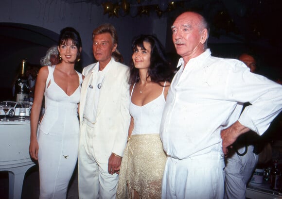 Caroline Barclay, Johnny Hallyday, sa femme Adeline Blondieau et Eddie Barclay lors de la soirée Blanche à Ramatuelle en juillet 1991