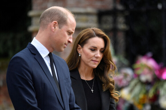 Le prince William, prince de Galles, et Catherine (Kate) Middleton, princesse de Galles regardent les hommages floraux laissés par les membres du public aux portes de Sandringham House à Norfolk, Royaume Uni, après la mort de la reine Elisabeth II. 