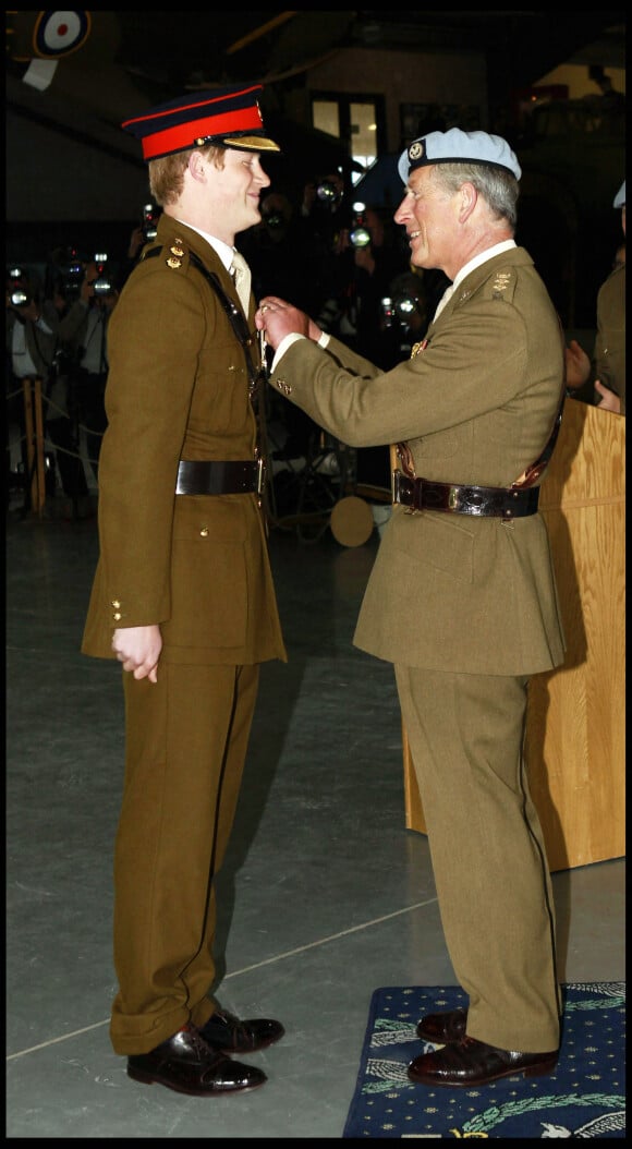 Le prince Harry reçoit des mains de son père, le prince Charles, ses ailes de pilote.