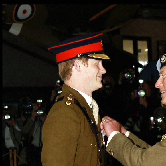 Le prince Harry reçoit des mains de son père, le prince Charles, ses ailes de pilote.