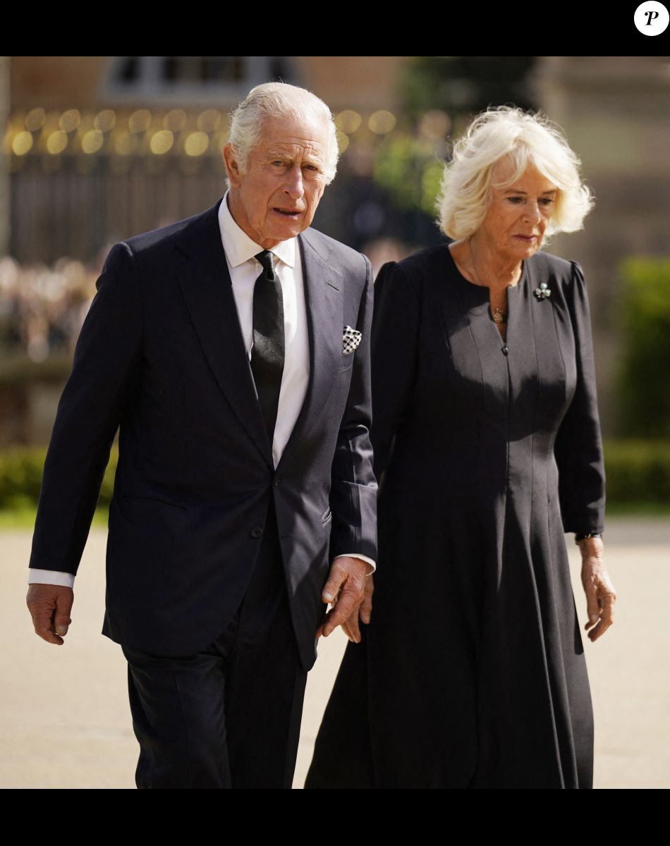 Le roi Charles III d'Angleterre et Camilla Parker Bowles, reine consort d'Angleterre, saluent la foule aux abords du château de Hillsborough à Belfast, le 13 septembre 2022.
