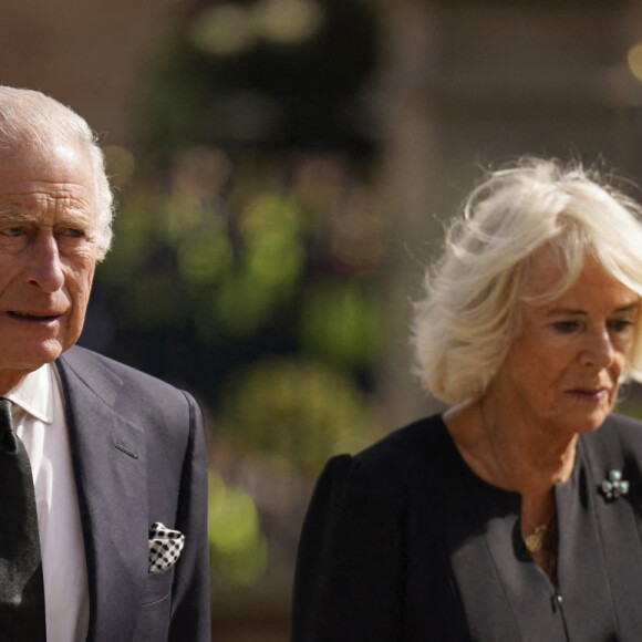 Le roi Charles III d'Angleterre et la reine consort Camilla Parker Bowles marchent le long des fleurs déposées en hommage à la reine Elisaberh II d'Angleterre, décédée le 8 septembre, devant le château de Hillsborough. Le 13 septembre 2022