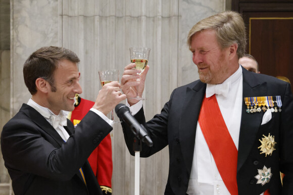 Le président Emmanuel Macron et le roi Willem Alexander des Pays-Bas portent un toast lors du dîner d'état au palais royal à Amsterdam le 11 avril 2023. Le président de la République et sa femme sont en visite d'état aux Pays-Bas. © Ludovic Marin / Pool / Bestimage 