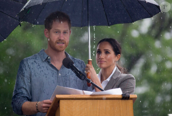 Le prince Harry, duc de Sussex a prononcé un discours aux côtés de sa femme Meghan Markle, duchesse de Sussex (enceinte) sous la pluie au parc Victoria Park de la ville de Dubbo en Australie dans le cadre de leur première tournée officielle, le 17 octobre 2018. Le couple a rencontré les agriculteurs de la région de l'est, zone frappée par la sécheresse. Un orage a eclaté et c'est sous un parapluie (tenu par la duchesse) que le prince Harry a fait son discours.  The drought stricken of Dubbo was given two surprises today when the Duke and Duchess of Sussex arrived - and so did the rain. The Duchess held an umbrella for her husband in a sweet gesture. on October 17th 2018