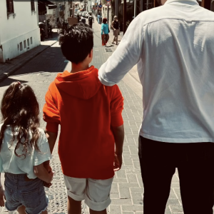 En train de marcher au soleil dans la rue, la petite Manava tient la main d'Aaron, lequel avance au côté de l'aîné Samuel, le bras posé sur l'épaule de son petit frère.
Arthur partage une rare photo de ses trois enfants réunis - Instagram
