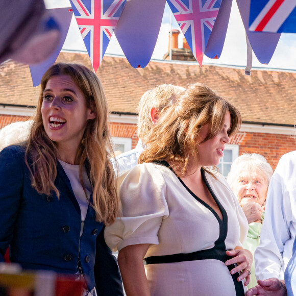 La princesse Eugenie d'York, enceinte, et la princesse Beatrice d'York (veste bleue) assistent au "Big Lunch" du couronnement à Chalfont St Giles (Buckinghamshire), le 7 mai 2023. Des centaines de sujets britanniques à travers le pays fêtent le sacre du roi d'Angleterre et de la reine consort, célébré la veille à l'abbaye de Westminster à Londres. 
