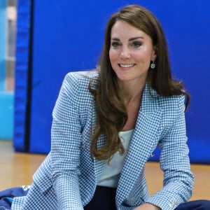 Elle l'a associé à un pantalon bleu marine et des escarpins plats en daim de la maison Emmy London, vendus au prix de 470 euros. 
Catherine (Kate) Middleton, princesse de Galles, au Windsor Family Hub à Windsor, le 6 juin 2023. Cette visite a pour but d'en savoir plus sur le travail effectué par l'organisation pour fournir un soutien aux familles de Windsor, Maidenhead et des environs. 