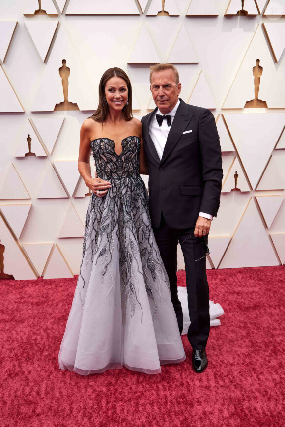 En effet, le couple a décidé de divorcer. 
Christine Baumgartner et Kevin Costner lors de la 94ème édition de la cérémonie des Oscars au théâtre Dolby, à Los Angeles, Californie, Etats-Unis, le 27 mars 2022. 